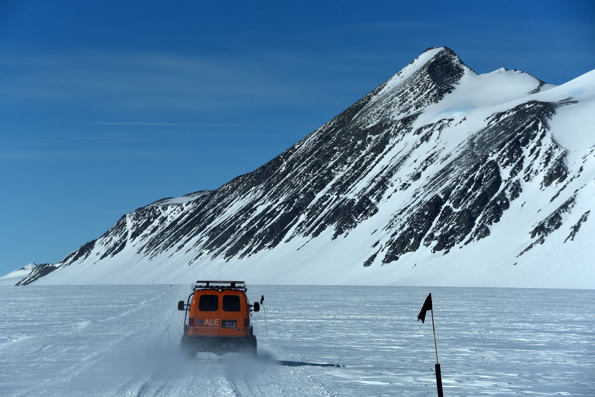13A ALE Van Driving From Union Glacier Runway To Glacier Camp With Mount Rossmann On The Way To Climb Mount Vinson In Antarctica